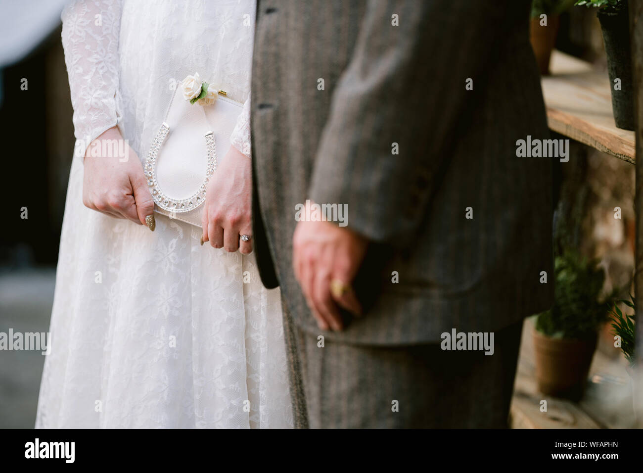 Detail von Brautpaar und Bräutigam, die mit einer Frau verheiratet werden, die glückliches Hufeisen hält Stockfoto