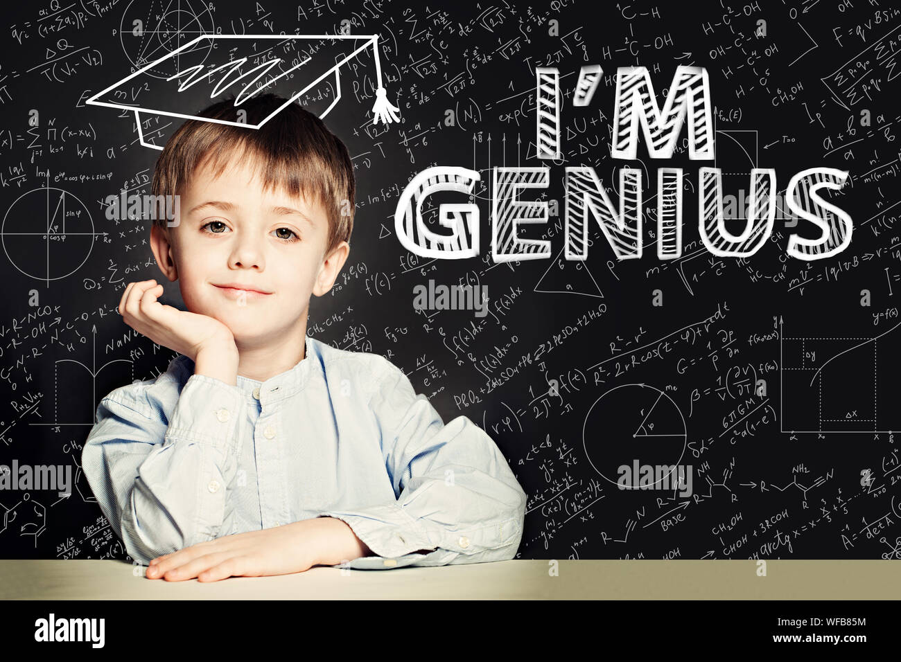 Glückliche Schüler Junge auf blackboard Hintergrund mit Wissenschaft und Mathematik Formel Stockfoto