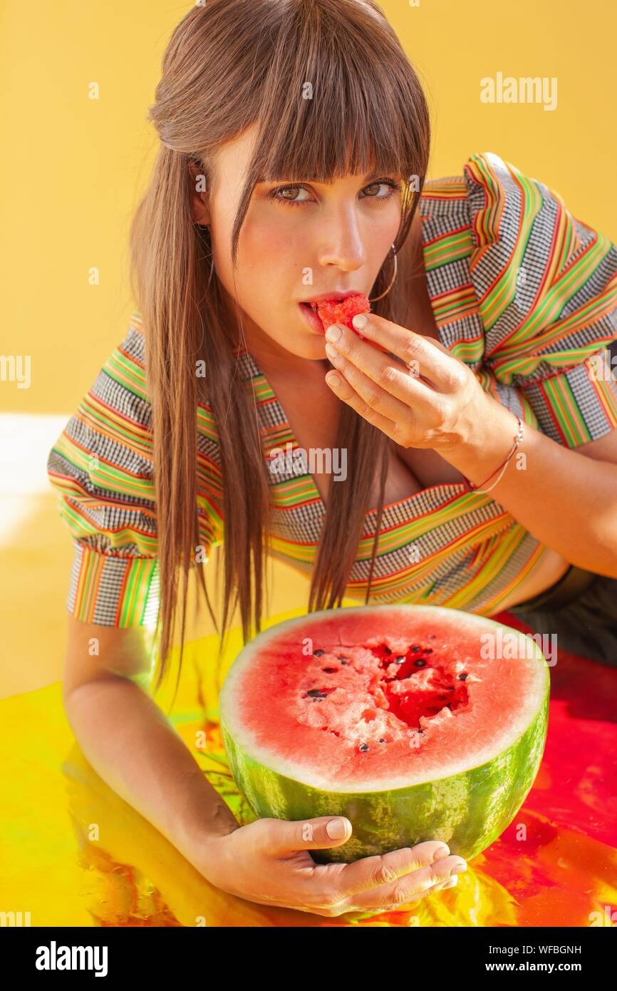 Porträt eines lächelnden Frau liegend auf die holographische Folie essen Wassermelone Stockfoto