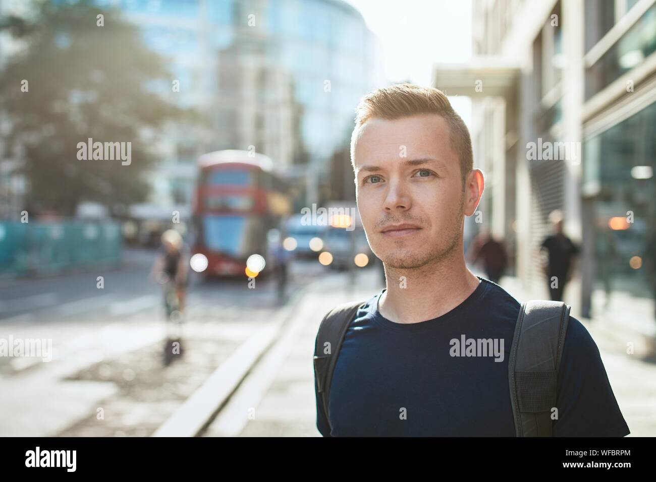 Portrait des jungen Mannes gegen Stadt Straße mit dem Bus Öffentliche Verkehrsmittel. London, Vereinigtes Königreich Stockfoto