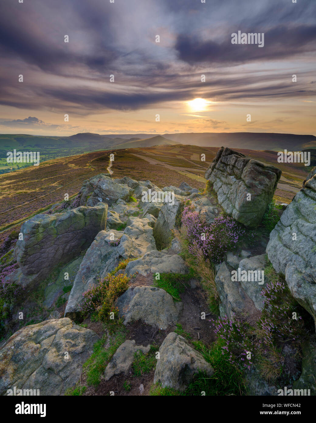 Win Hill, Großbritannien - 12.August 2019: Sonnenuntergang über den Peak District von Win Hill mit den Anfängen der Heidekraut blüht. Stockfoto