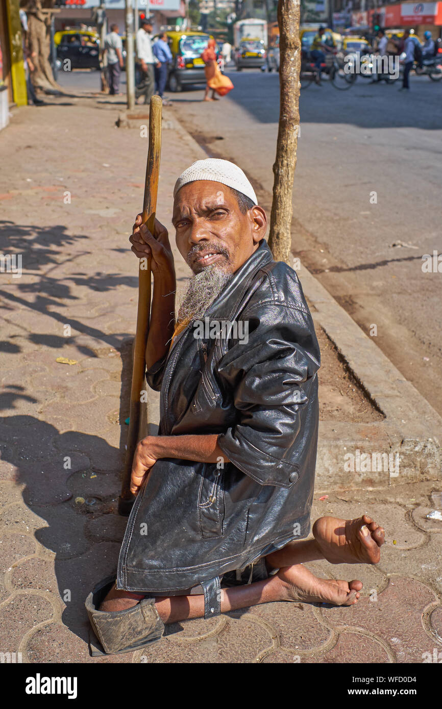 Ein behinderter Bettler auf einem Bürgersteig in Mumbai, Indien hocken Stockfoto