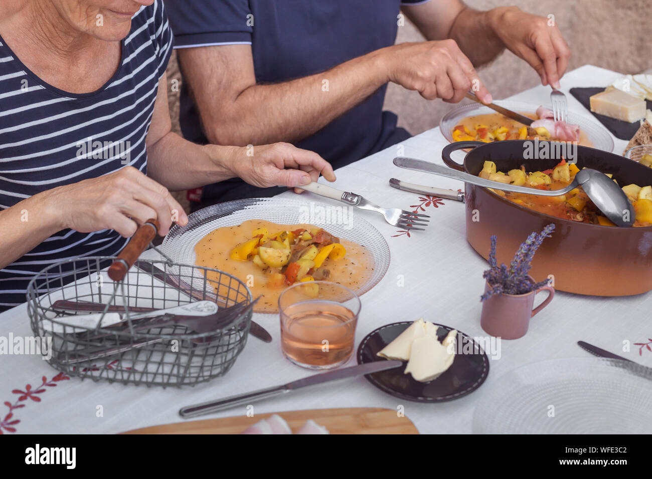 Hände der Ältesten Paar Abendessen zusammen hausgemachte Speisen Prozess des Essens der weißen Tischdecke Stockfoto