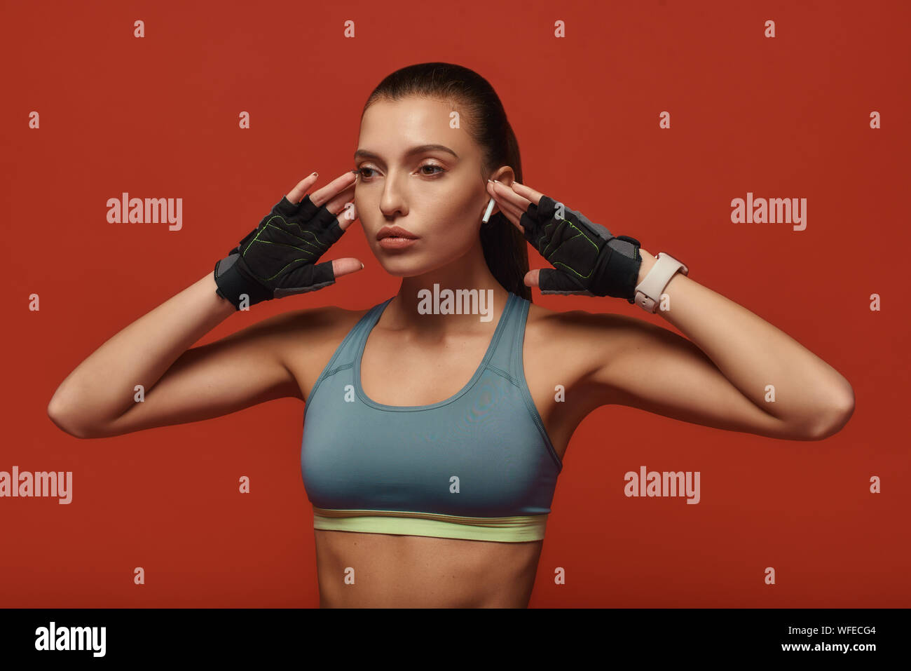 Porträt der jungen Mädchen mit sport-Bh zur Seite schauen beim Stehen über den roten Hintergrund. Fitness- und Arbeit Konzept vor. Horizontale Schuß Stockfoto