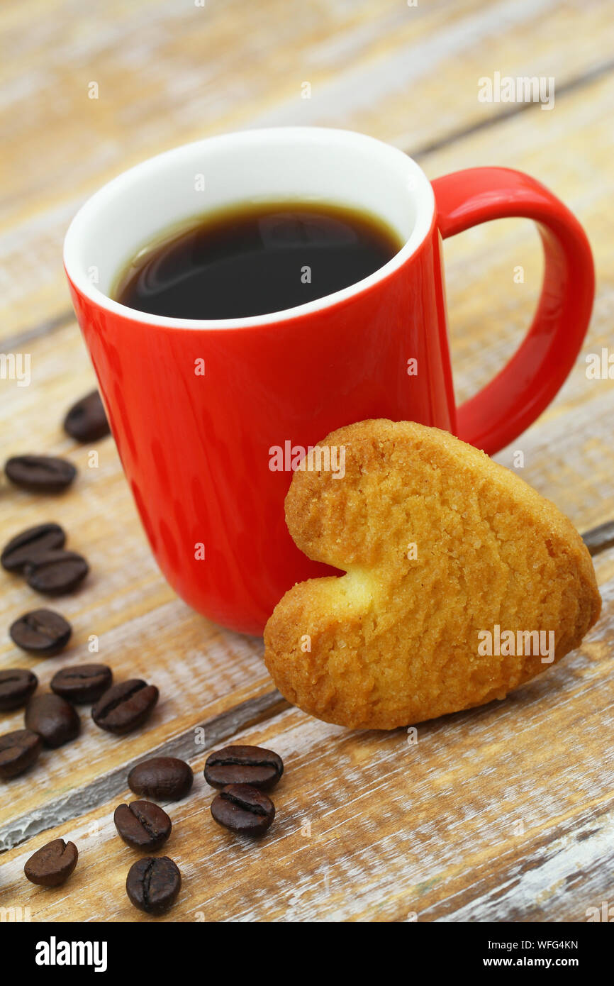 Herzform cookie gegen rote viel schiefen mit schwarzen Kaffee Stockfoto