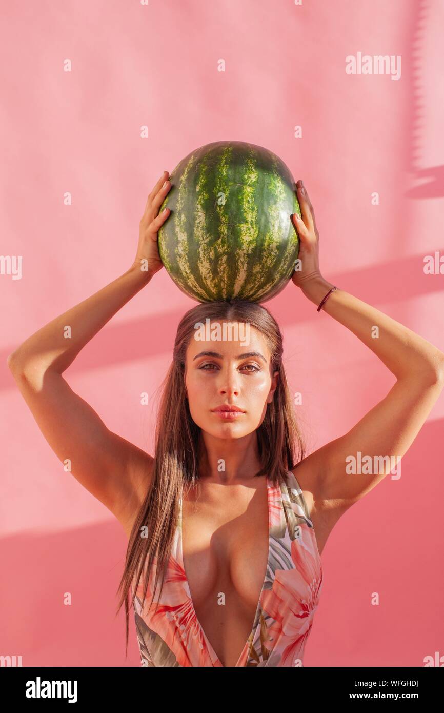 Frau mit einem Wassermelone über ihrem Kopf Stockfoto