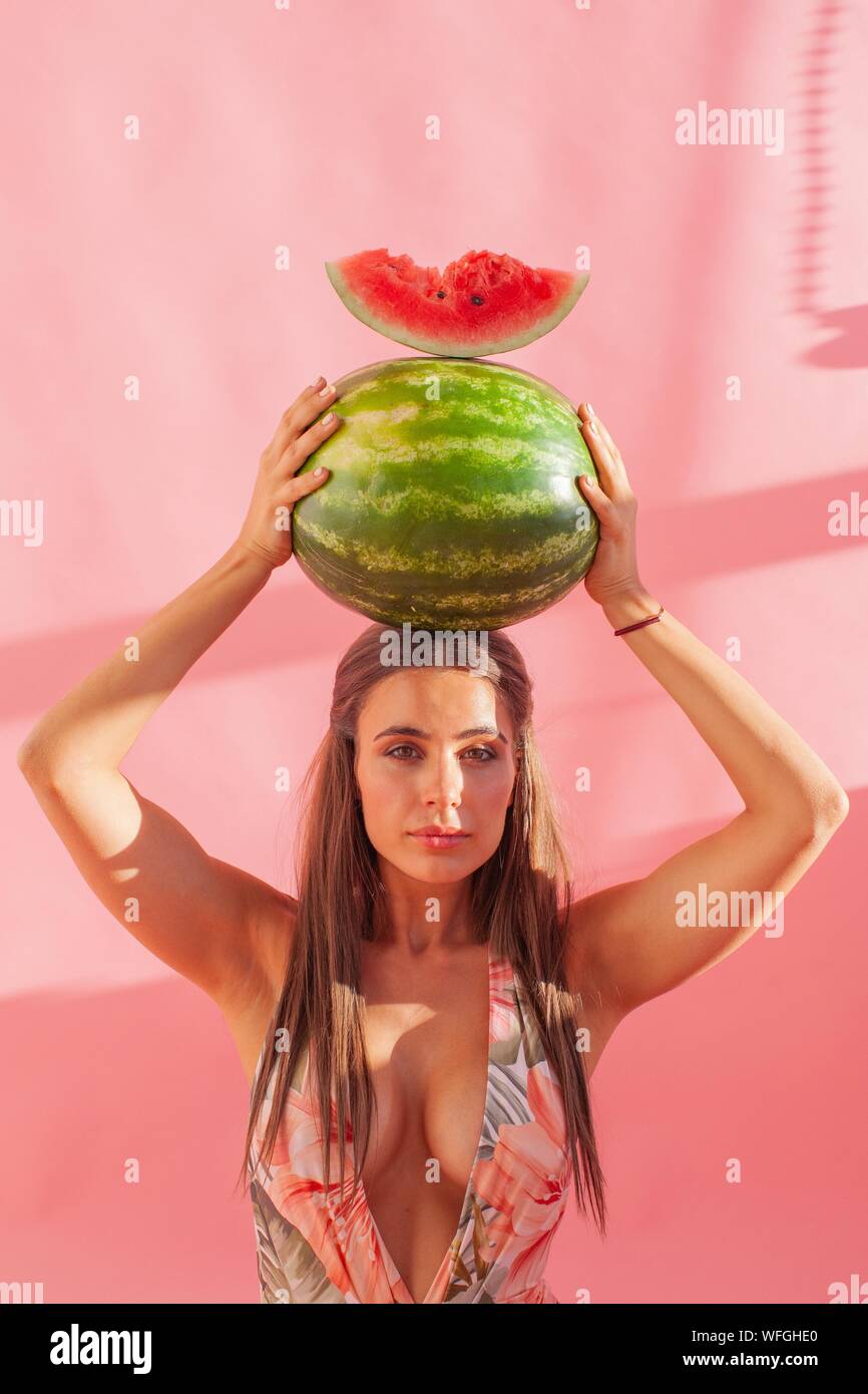 Frau mit einem Wassermelone über ihrem Kopf Stockfoto