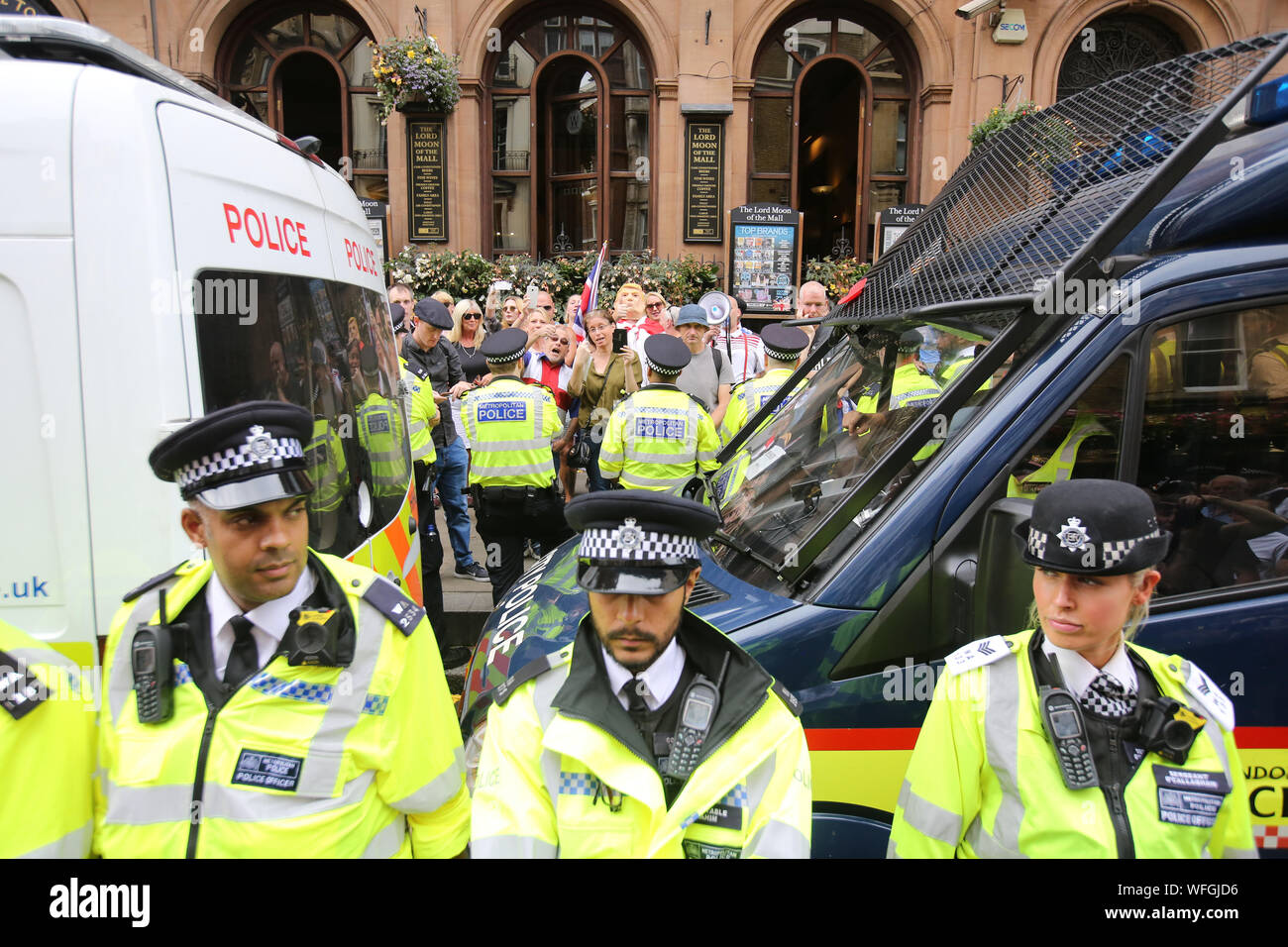 Polizeibeamte stehen vor pro Brexit Unterstützer an der 'Lasst uns 'Tag der Aktion, durch Ein anderes Europa ist möglich Kampagne Gruppe in London gegen Premierminister Boris Johnson die Entscheidung des Parlaments für bis zu fünf Wochen auszusetzen, vor der Queen's Speech am 14. Oktober unter Beweis zu stellen. Stockfoto