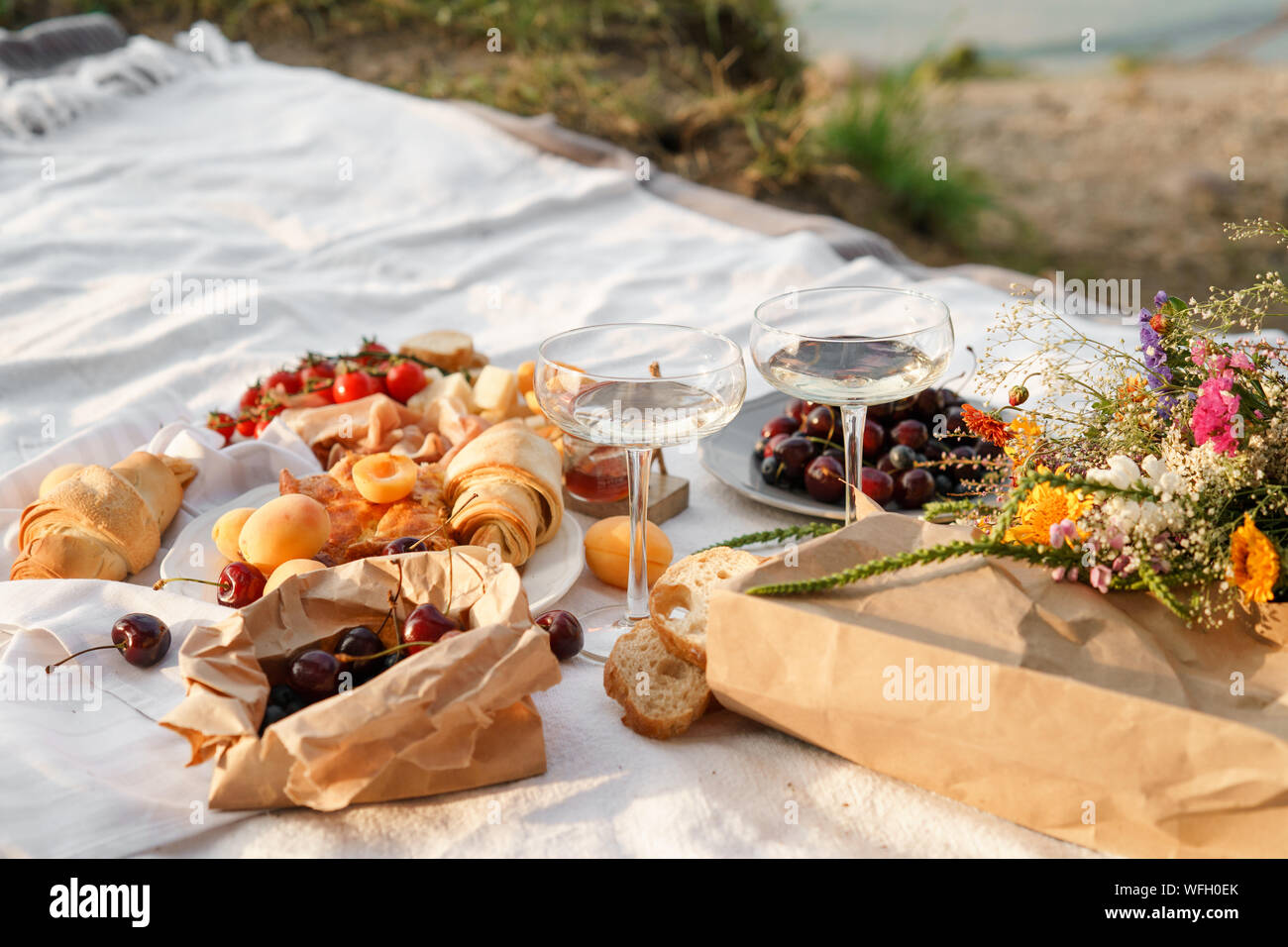 Das Essen bei einem Picknick und Gläser Wein auf einer Decke Stockfoto