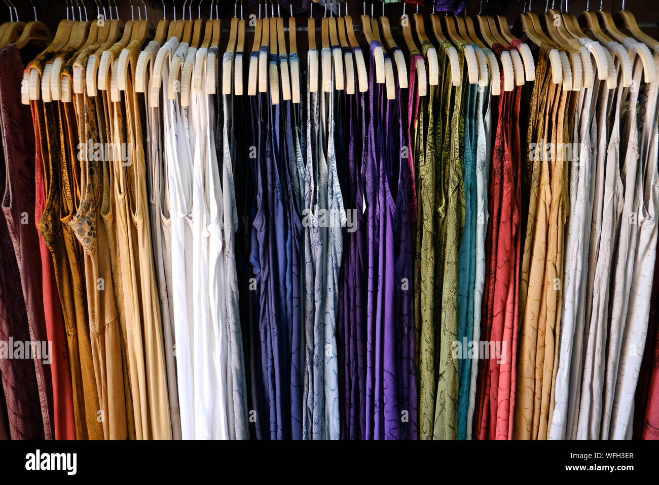 Mehrfarbige Kleider im Schrank hängen Stockfoto