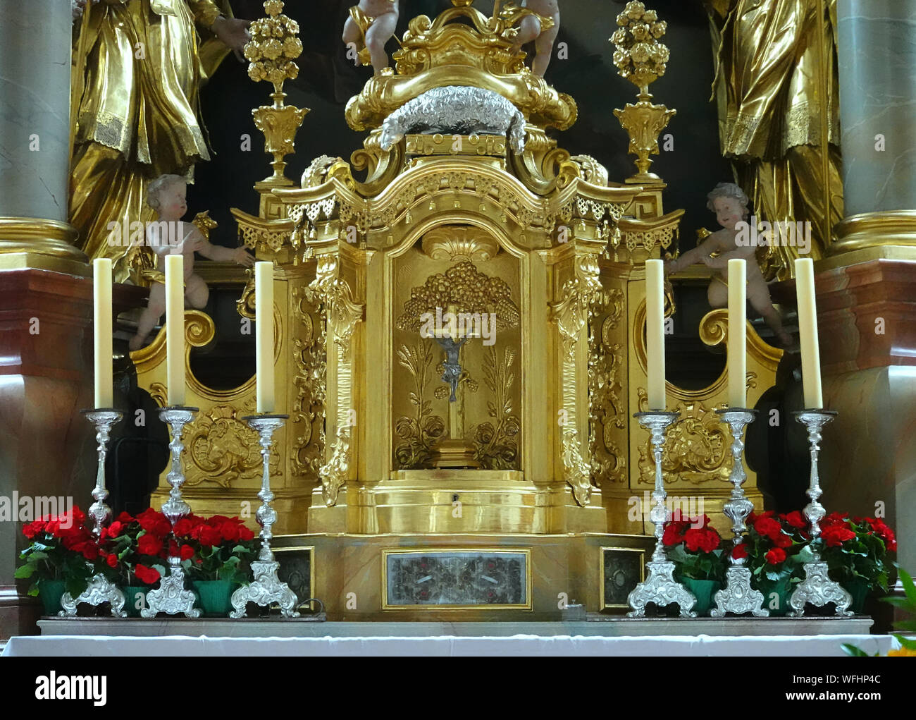 Mittenwald, Deutschland, 10. August, 2019: Halter Kerze mit Kerzen, Rosen und Schmuck vor der vergoldete und versilberte Altar der Katholischen Kirche Stockfoto