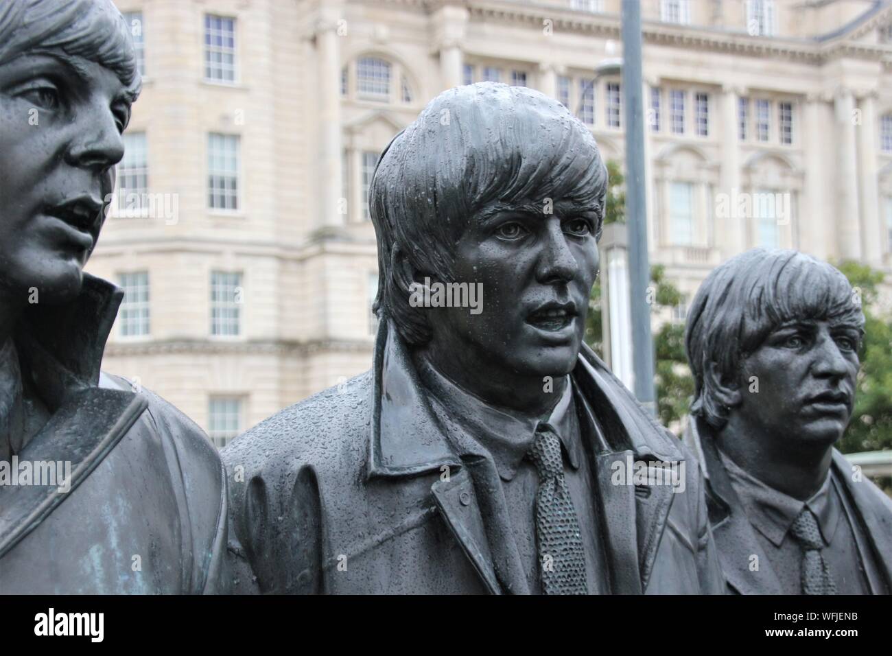 Skulptur der Beatles auf Pier Head, Liverpool, England, bei Regenwetter. Detail: Portrait von Paul, George und Ringo. Artist: Andy Edwards. Europa. Stockfoto