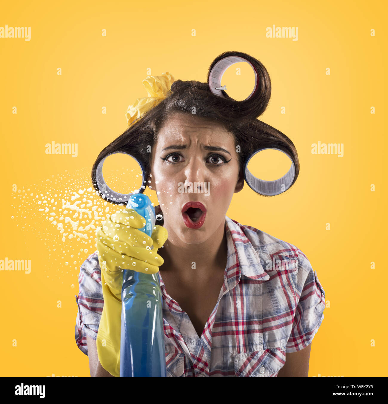Mädchen Hausfrau mit Handschuhen und Spray bereit zu reinigen Stockfoto