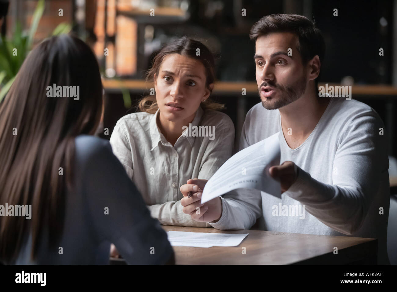 Wütend Paar argumentieren mit Bank manager Klagen auf schlechten Vertrag Stockfoto