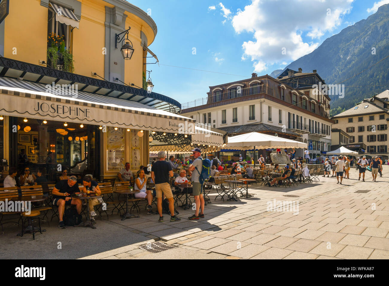 Blick auf die Straße des Stadtzentrums mit Touristen laufen und sitzen im Café und Bistro in einem sonnigen Sommertag, Chamonix-Mont-Blanc, Frankreich Stockfoto