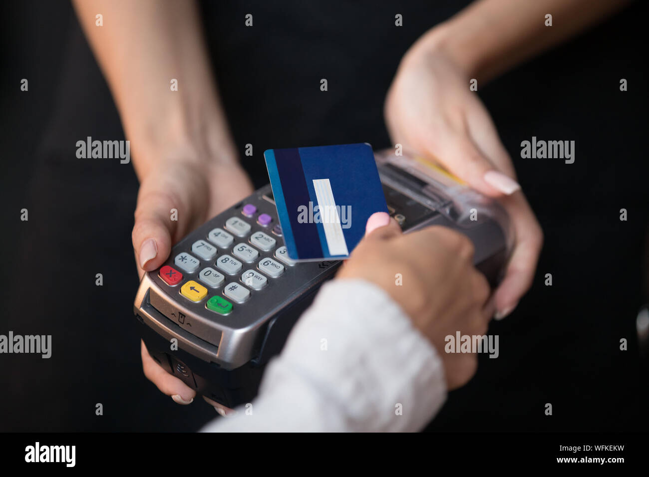 Weibliche Kunden halten Kreditkarte verwenden, kontaktlosen NFC-Technologie Stockfoto