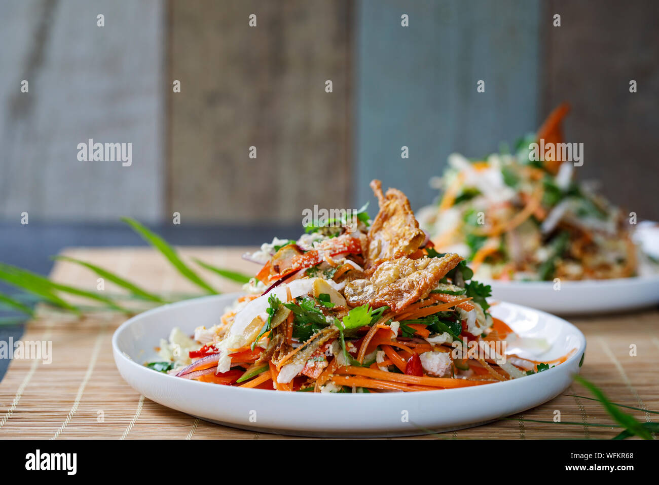 Thai Salat mit frischem Gemüse, pochiertem Huhn und knusprige Hähnchen Haut Stockfoto