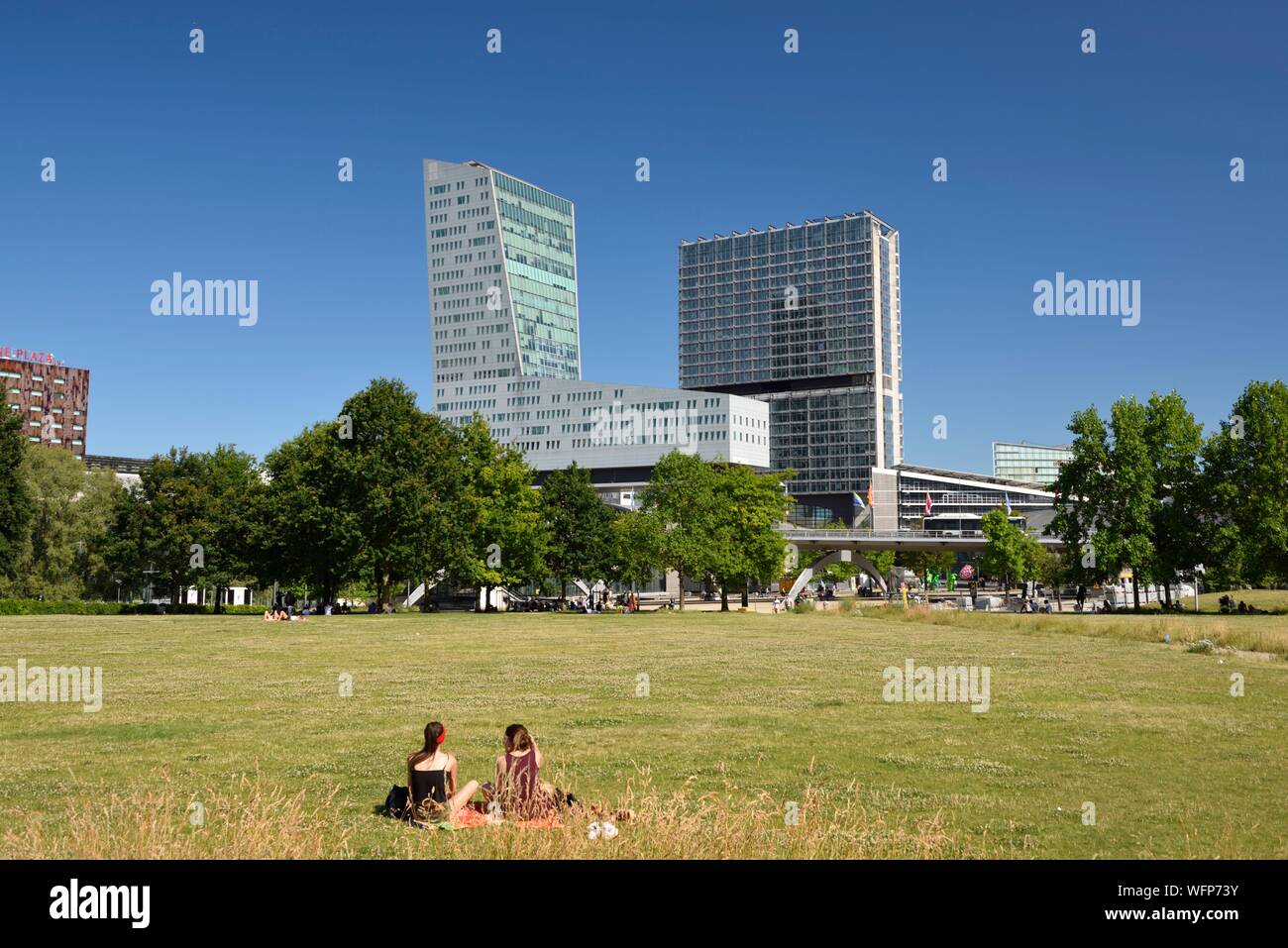 Frankreich, Nord, Lille, Henri Matisse mit dem Geschäftsviertel Euralille, dem Eurostar Bahnhof und dem TGV-Bahnhof Lille Europe Lille, die von der Turm und die Lilleurope Turm enthält, zwei junge Frauen im Gras sitzen Stockfoto