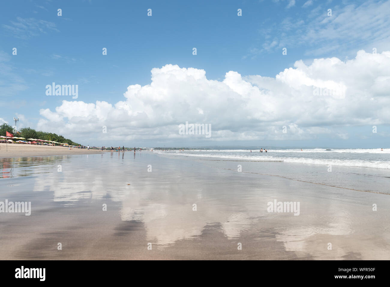 Weiße Wolken auf dem nassen Sand am Strand von Legian Bali Indonesien an einem schönen Tag in der trockenen Jahreszeit wider Stockfoto