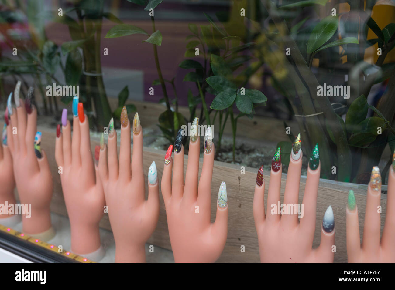 Hände mit dem Fingernagel Erweiterungen an einem Schaufenster Stockfoto
