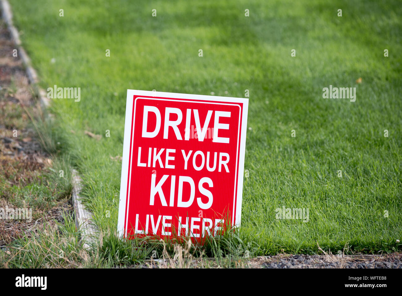 'Drive wie Ihre Kinder leben hier' Zeichen auf einem Rasen in Wallowa County, Oregon. Stockfoto