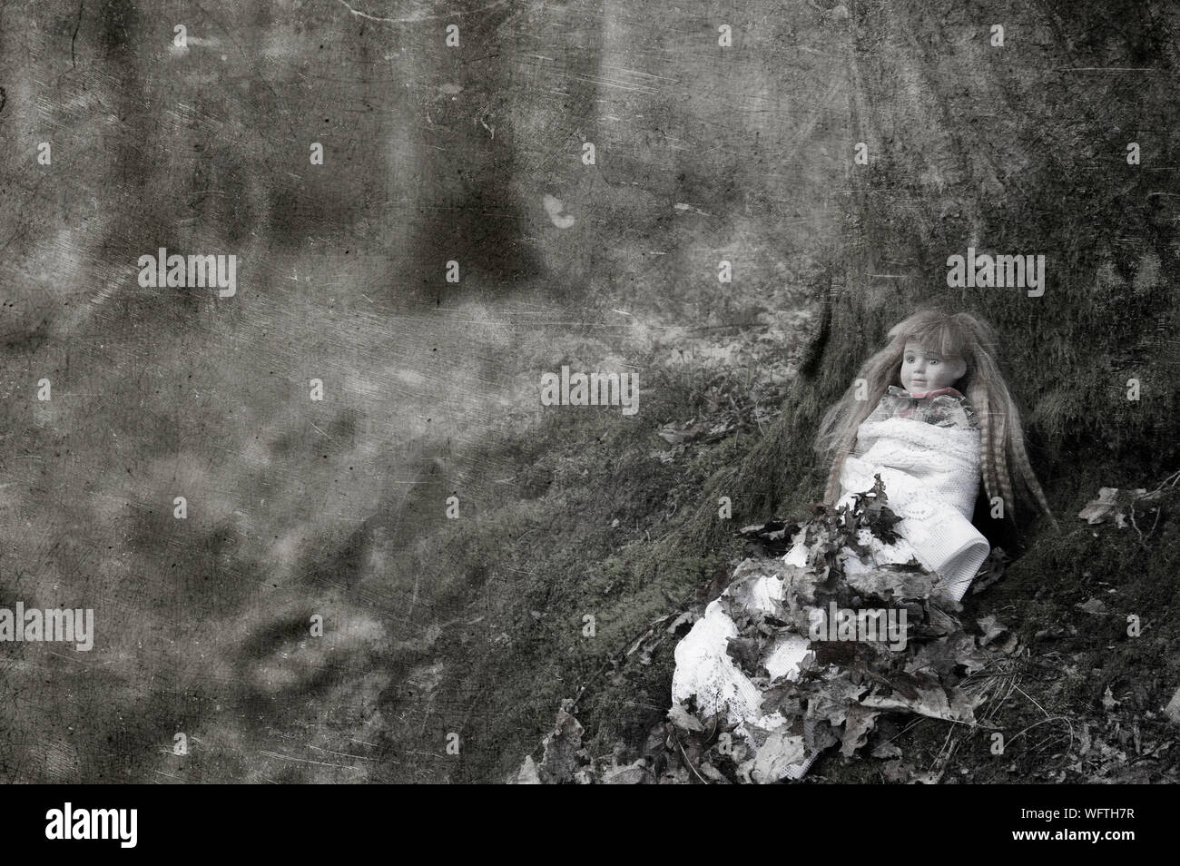 Eine ceepy spooky Doll, sitzen in einem Wald im Winter, die neben einem Baum. Mit einer strukturierten, verwitterte, Sepia bearbeiten. Stockfoto