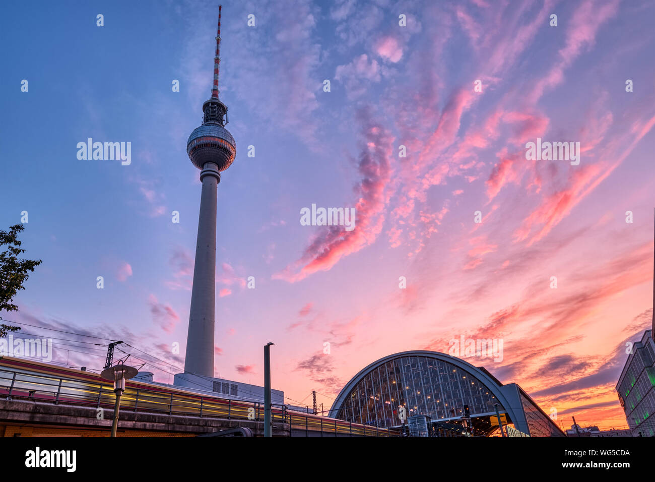 Zug mit Motion Blur und den berühmten Fernsehturm in Berlin bei Sonnenuntergang Stockfoto