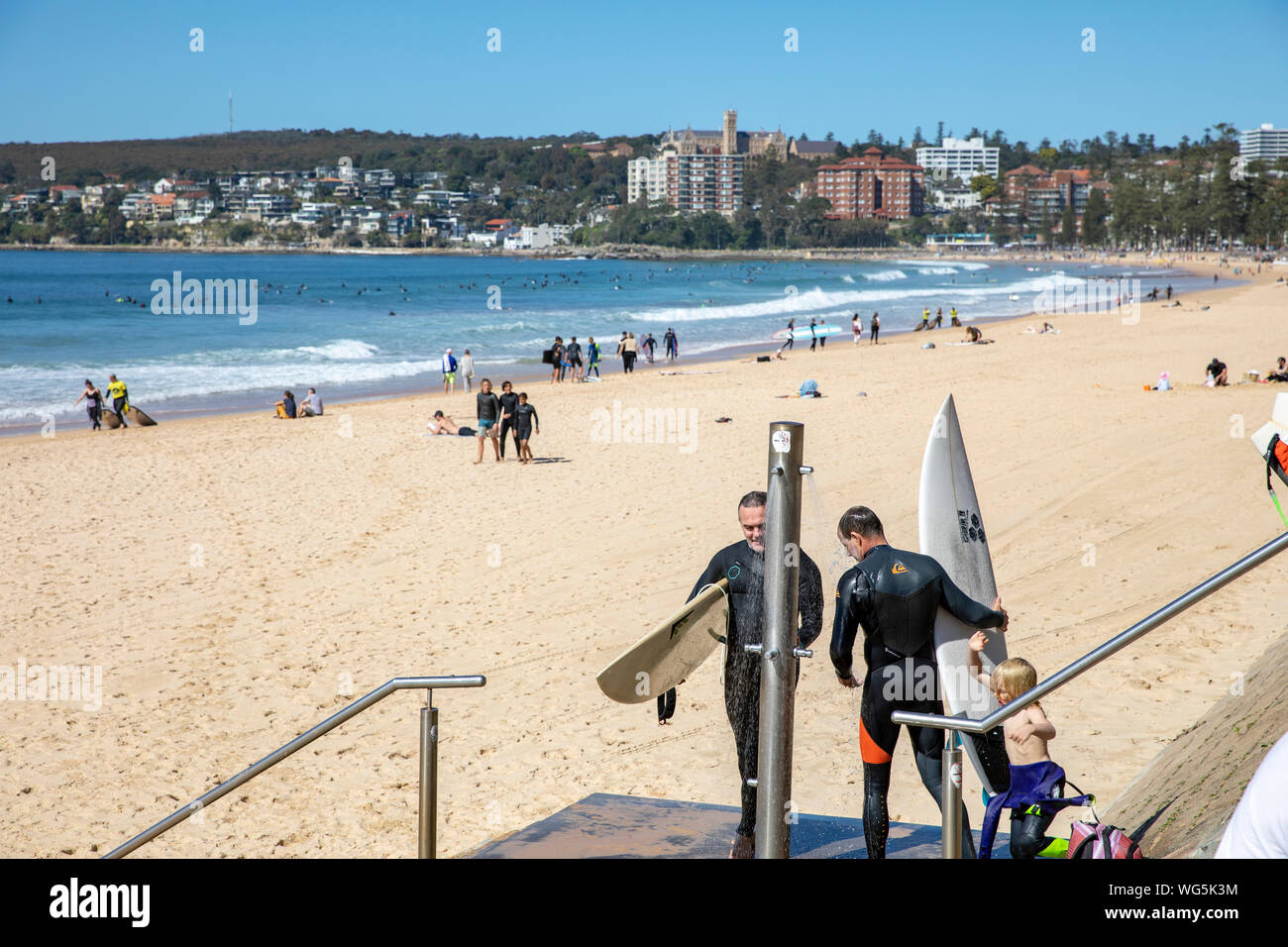 Surfer an Manly Beach in Sydney waschen ihre surfbretter unter den Strand Dusche, Sydney, Australien Stockfoto