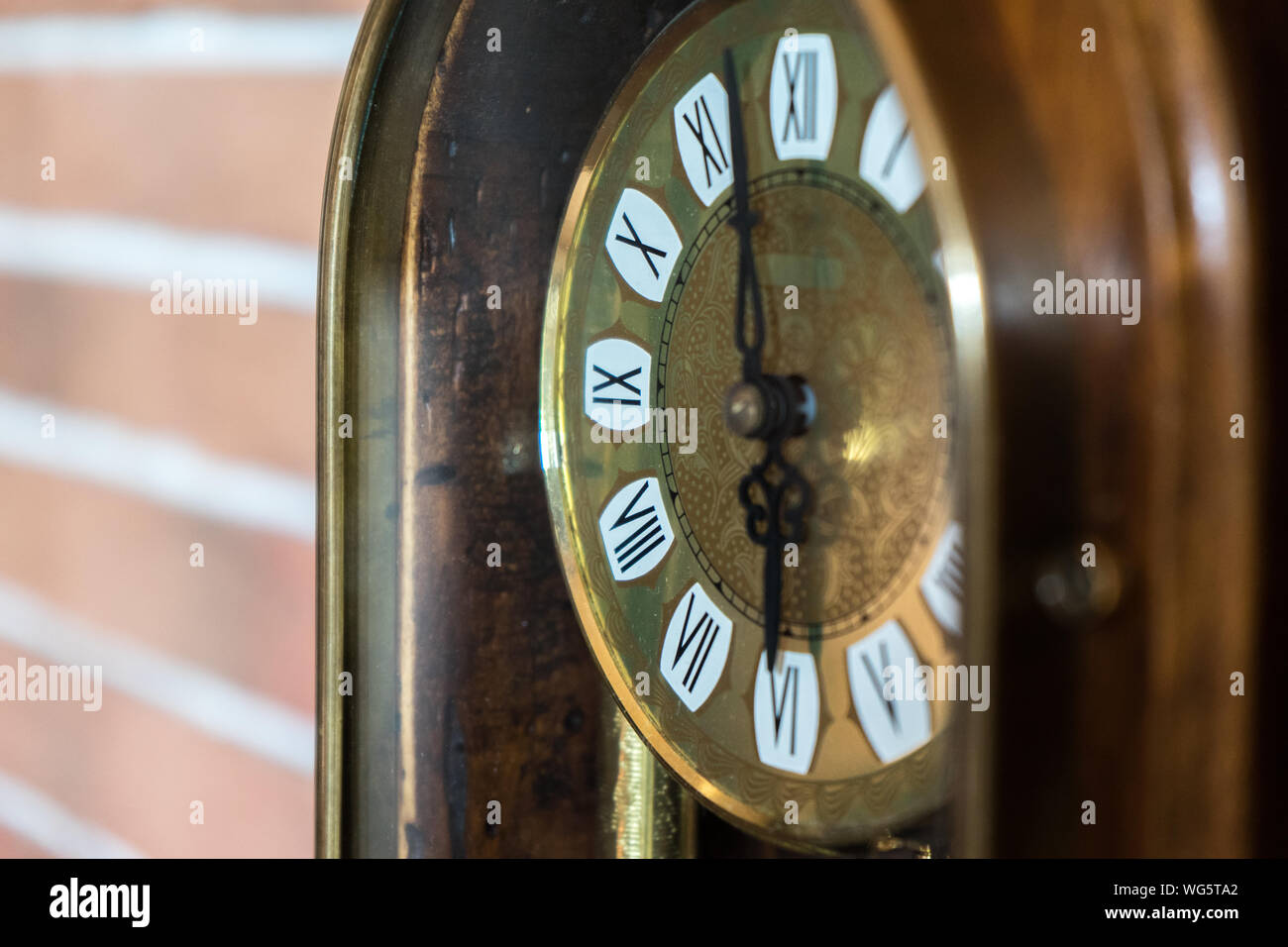 Eine Nahaufnahme eines antiken goldenen Holz- Uhr mit Mauer Hintergrund Stockfoto