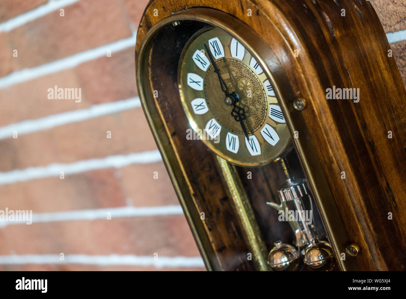 Eine Nahaufnahme eines antiken goldenen Holz- Uhr mit Mauer Hintergrund Stockfoto