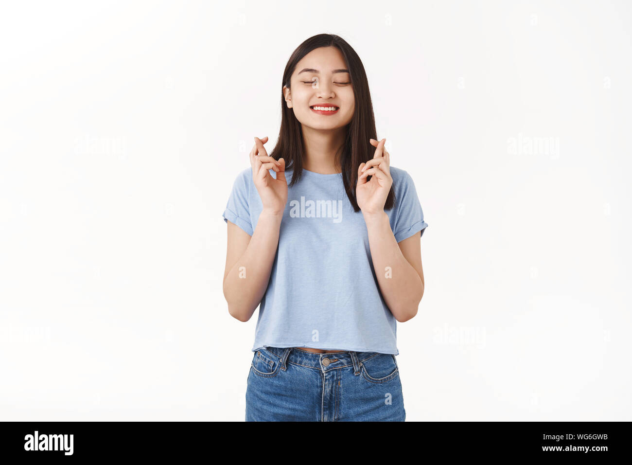 Aufgeregt glücklich Süße asiatische Mädchen ein Traum cross Finger viel Glück schließen Augen lächeln machen möchten Wunsch wahr Träumen bereit erfüllen Leistung gewinnen Stockfoto