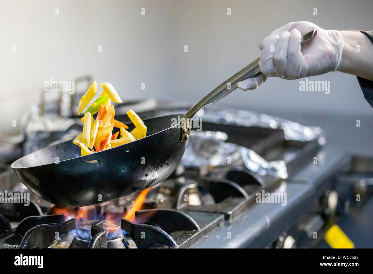 Koch ist das rühren Gemüse im Wok Stockfoto