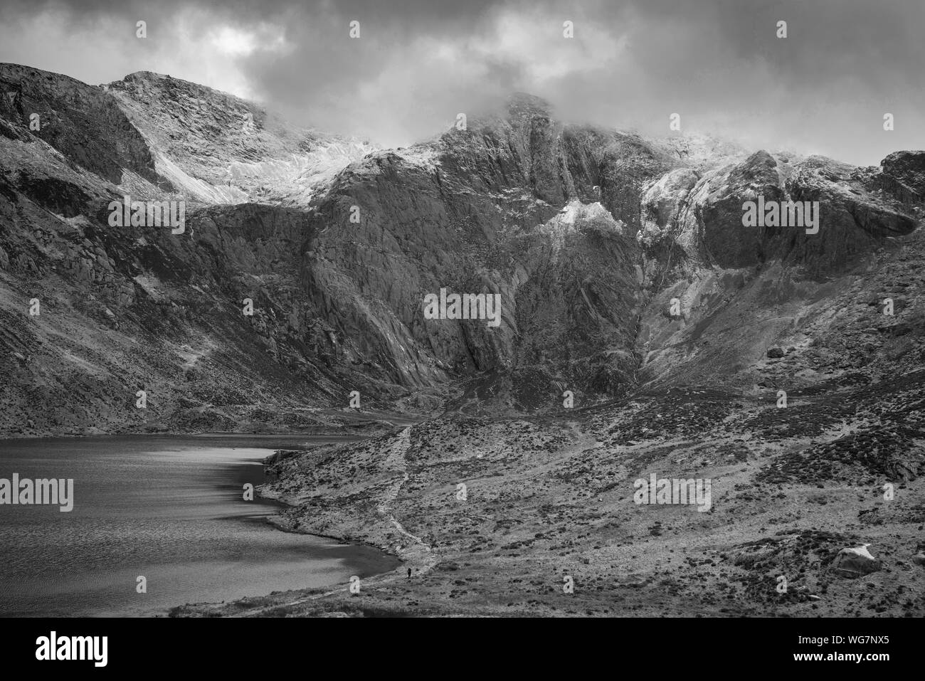 Atemberaubende dramatische Winterlandschaft Bild von Llyn Glyders Idwal und schneebedeckten Bergkette in Snowdonia in Schwarz und Weiß Stockfoto