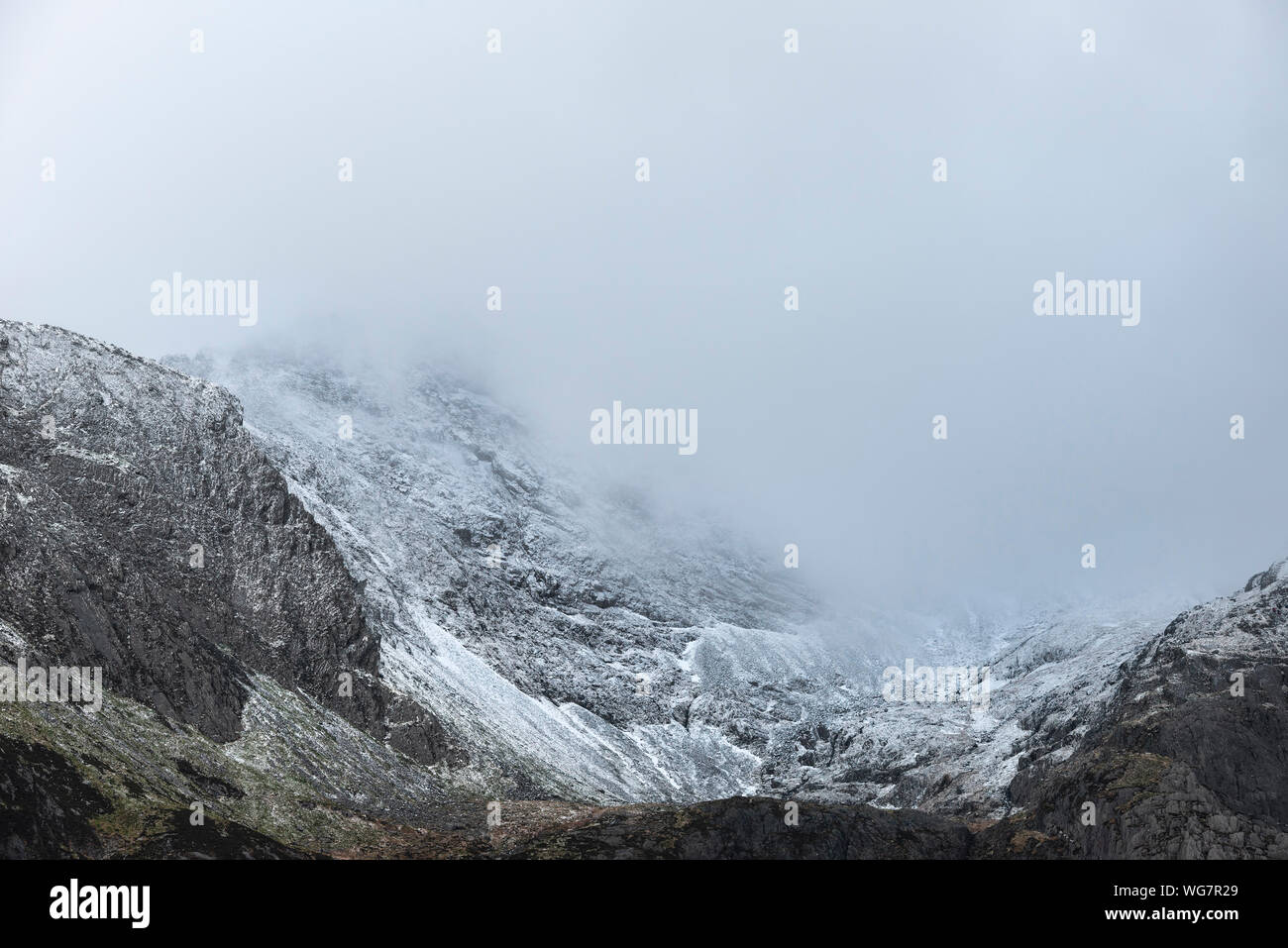 Atemberaubende dramatische Landschaft Bild von schneebedeckten Glyders Bergkette in Snowdonia im Winter mit bedrohlichen Wolken am Berg Erbse hängen Stockfoto