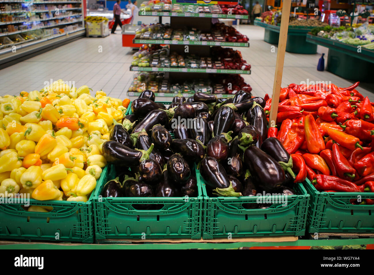 Rote Paprika, Auberginen und gelbe Paprika auf dem Obst und Gemüse Gang in einem Geschäft Stockfoto