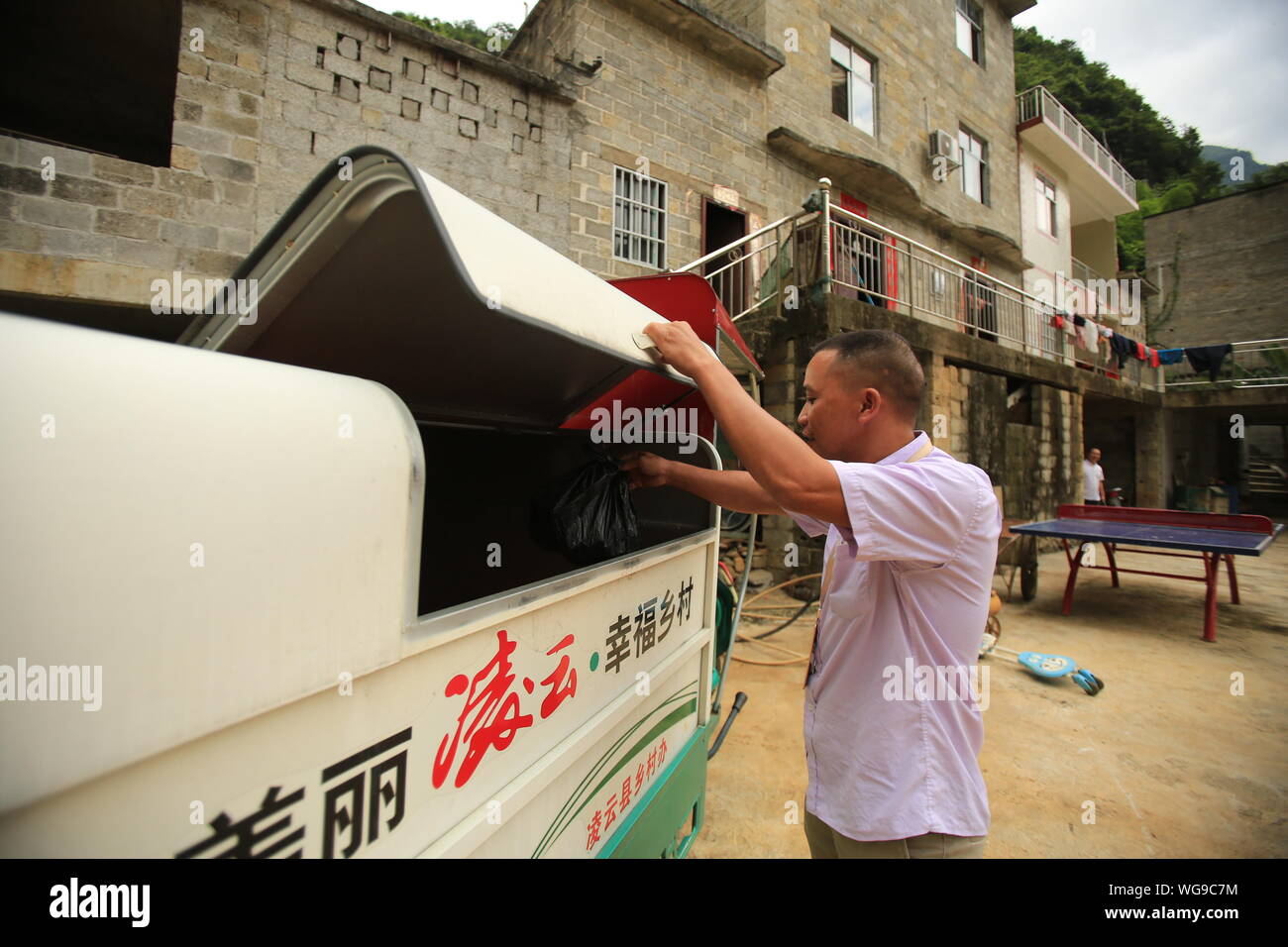 (190901) - LINGYUN, Sept. 1, 2019 (Xinhua) - Lao Ketuan wirft trashes in den Papierkorb Fahrzeug in Haokun Dorf Lingyun County, South China Guangxi Zhuang autonomen Region, Aug 30., 2019. Lao Ketuan, 40, lebt in den gebirgigen Dorf Haokun, einem Ort mit extrem schlechten Transport und knappen Landressourcen, die ernsthaft in die lokale Entwicklung behindert und die Menschen hier in Armut gefangen. Der laotische Familie ist unter den verarmten Haushalte, die hier leben. 2016, Lao hatte jedoch nie träumen lassen, dass seine Familie aus der Armut erhalten konnten dank der lokalen Behörden arbeiten Stockfoto