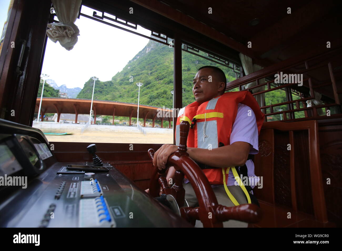 (190901) - LINGYUN, Sept. 1, 2019 (Xinhua) - Lao Ketuan fährt mit seinem Schiff an der Haokun Lake Scenic Spot in Lingyun County, South China Guangxi Zhuang autonomen Region, Aug 30., 2019. Lao Ketuan, 40, lebt in den gebirgigen Dorf Haokun, einem Ort mit extrem schlechten Transport und knappen Landressourcen, die ernsthaft in die lokale Entwicklung behindert und die Menschen hier in Armut gefangen. Der laotische Familie ist unter den verarmten Haushalte, die hier leben. 2016, Lao hatte jedoch nie träumen lassen, dass seine Familie aus der Armut erhalten konnten dank der lokalen Behörden arbeiten auf pov Stockfoto