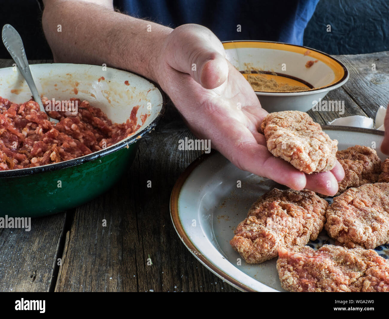 Zugeschnittenes Bild von Händen Teig Mischen von Hackfleisch am Tisch Stockfoto