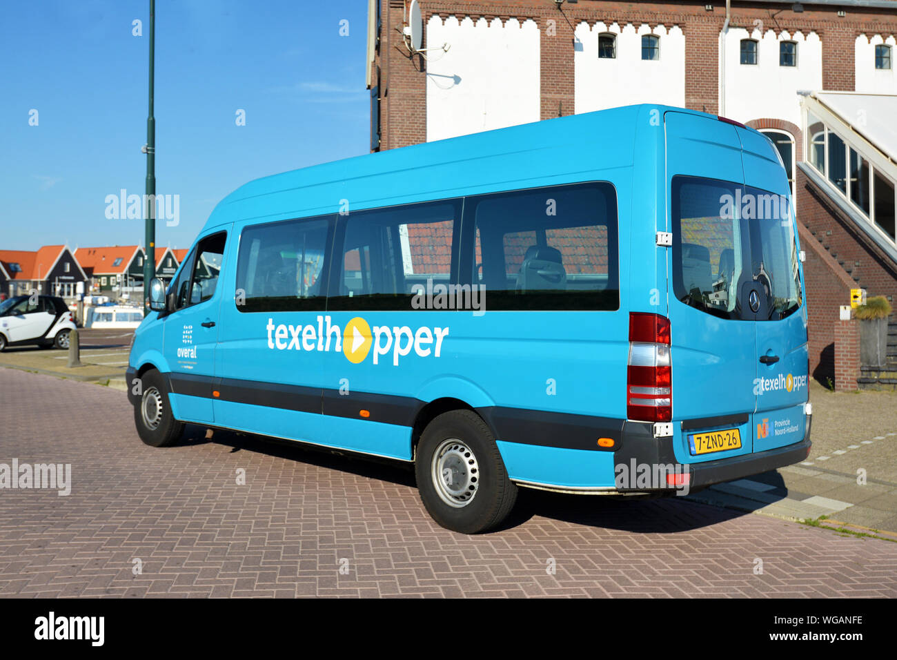 Oudeschild Texel / Niederlande - August 2019: Kleine blaue Bus van namens 'Texelhopper' Stockfoto