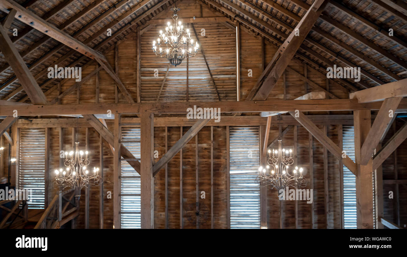 Blick in das Innere eines Timber Frame Fancy Scheune mit Kronleuchtern und Windows Stockfoto