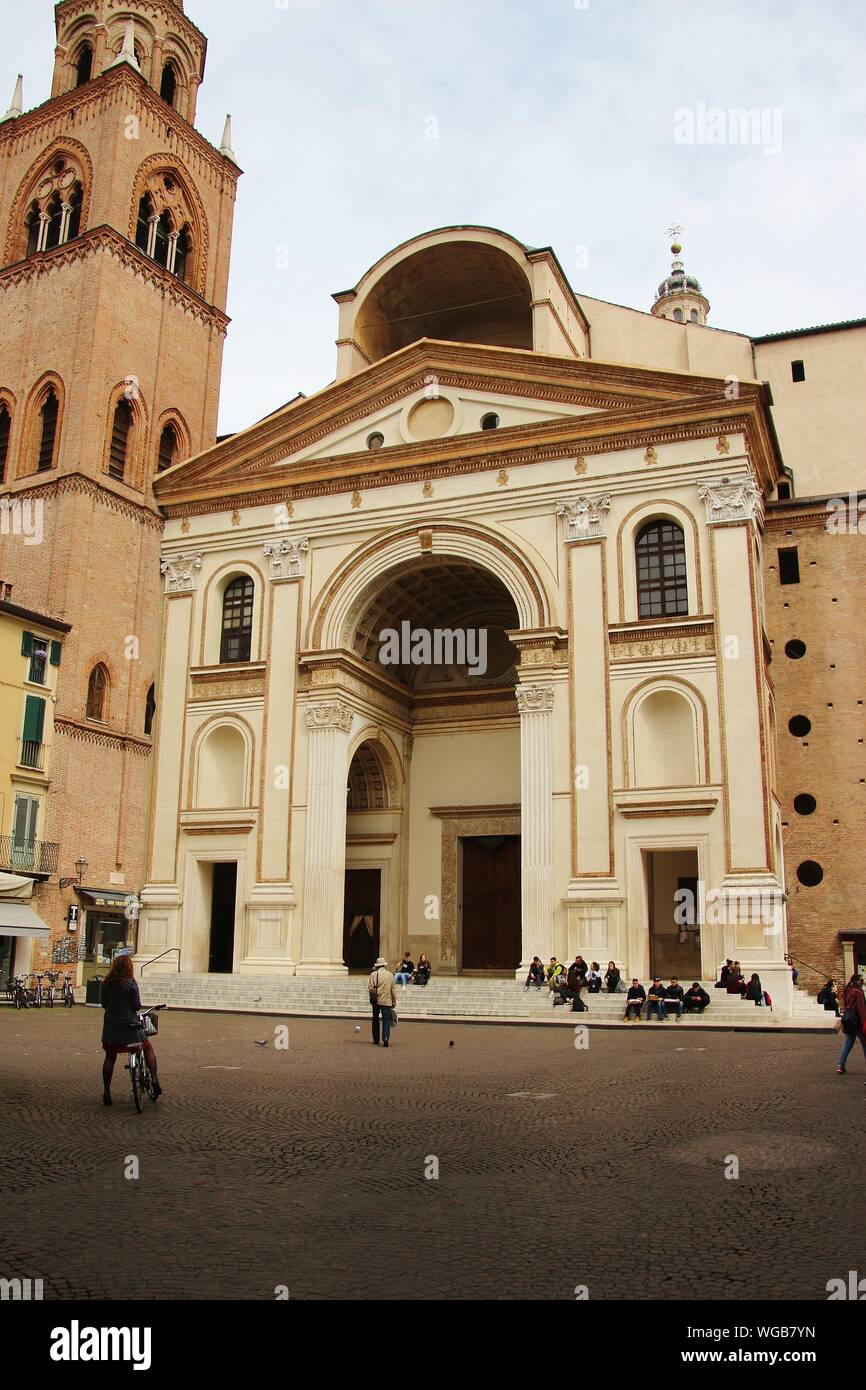 Piazza Andrea Mantegna und Haupteingang Portal der Basilika Sant Andrea, Mantua. Die Leute sitzen auf der Treppe. In Norditalien, in Europa. Stockfoto