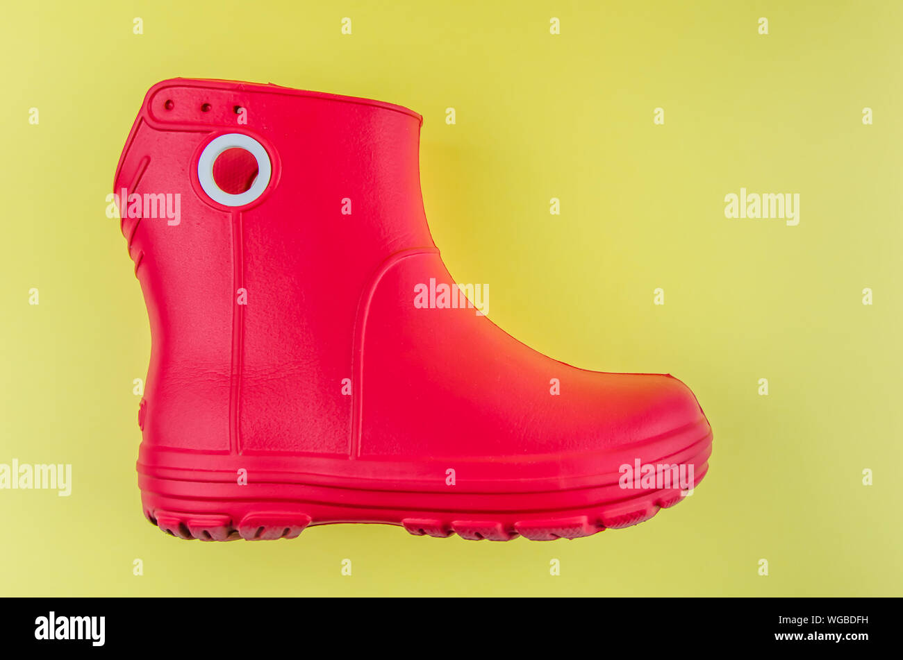 Red Rubber Boots EVA auf gelbem Hintergrund. Stockfoto