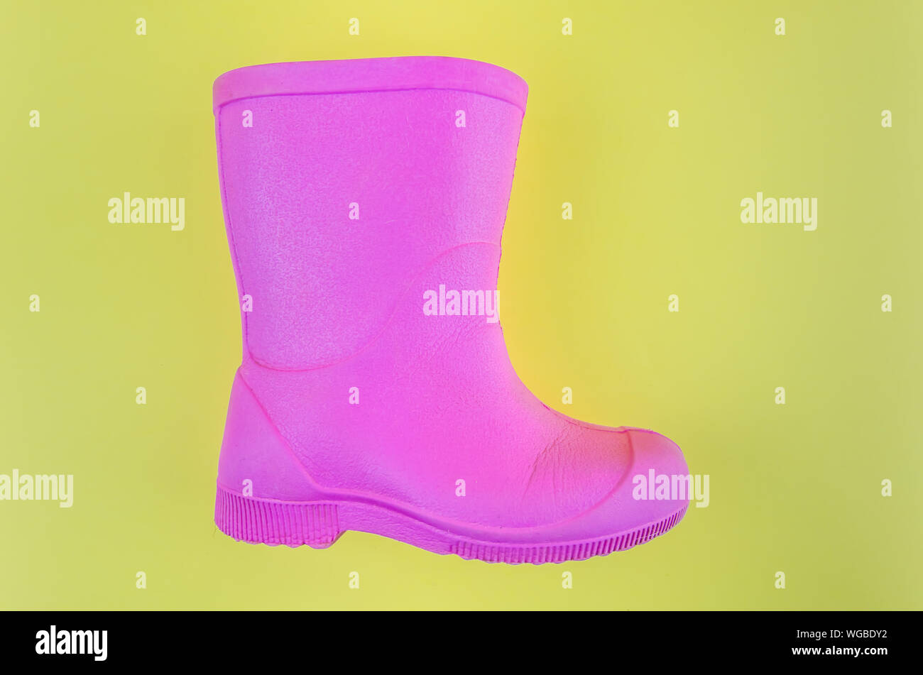 Kinder rosa Gummistiefel EVA auf gelbem Hintergrund. Stockfoto