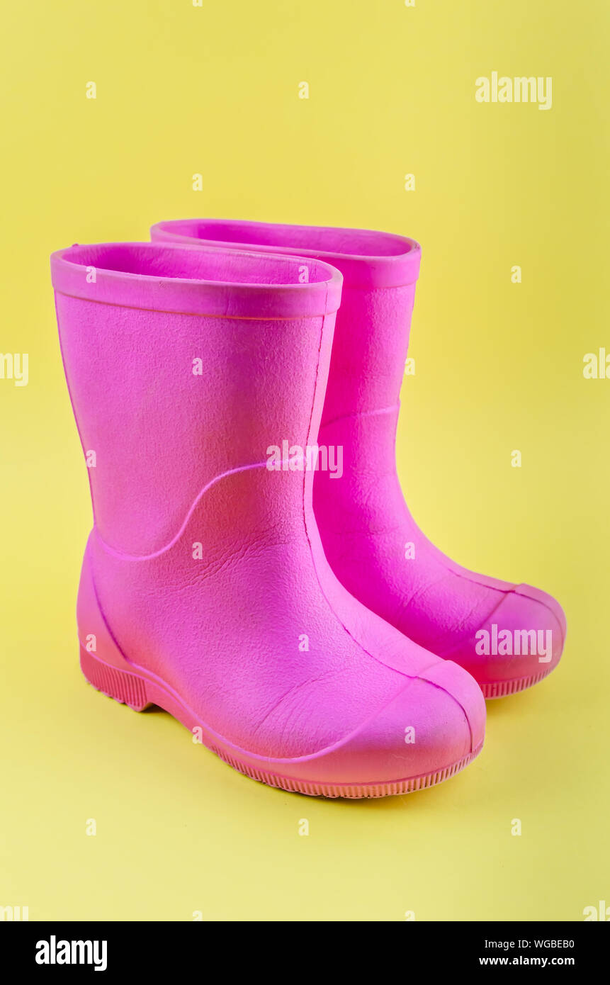 Kinder rosa Gummistiefel EVA auf gelbem Hintergrund. Stockfoto