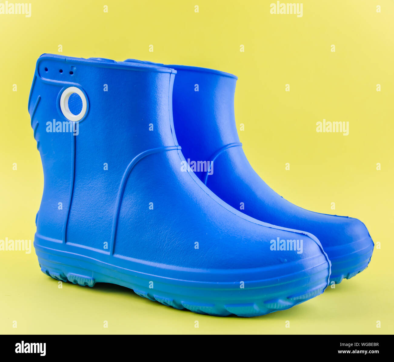 Blaue Gummistiefel EVA auf gelbem Hintergrund. Stockfoto