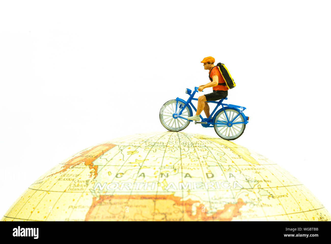 Miniatur Menschen Reiten Fahrrad rund um den Globus isoliert auf weißem Hintergrund schließen oben. Bild Konzept. Stockfoto