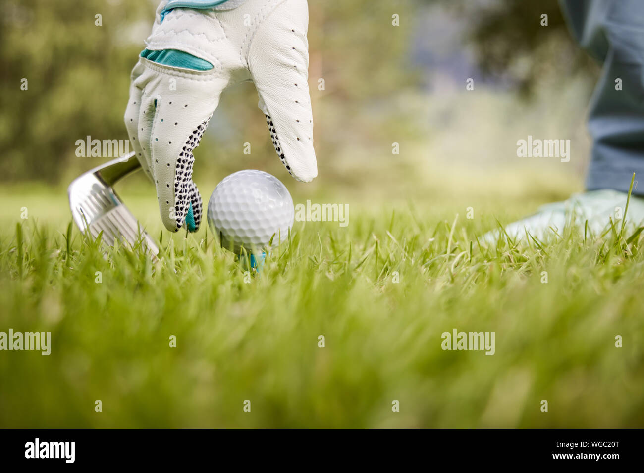 Hand in Hand platzieren Golfball auf T-Stück Stockfoto