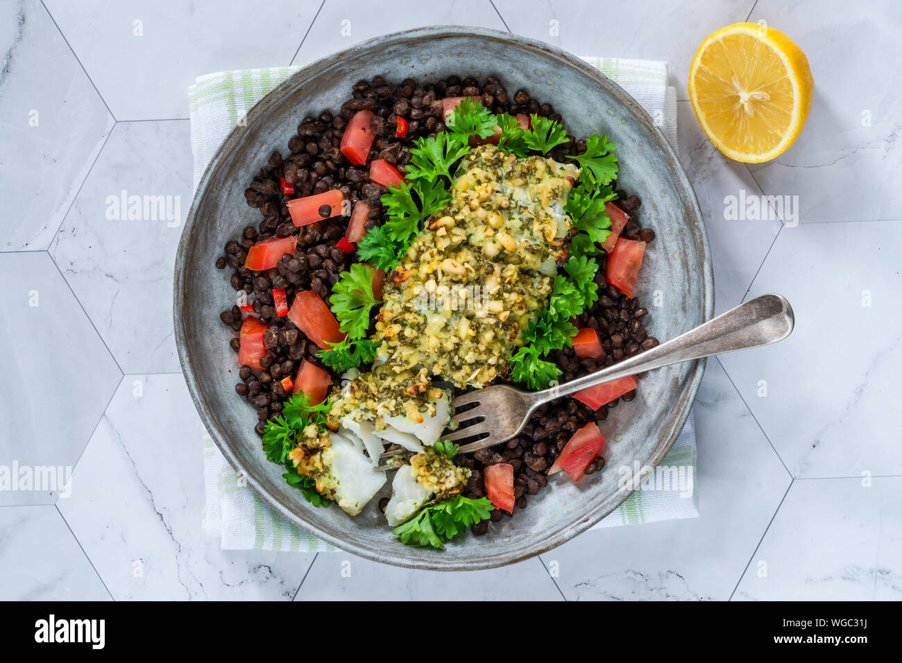Pesto - verkrusteten Kabeljau mit Puy Linsen und Tomaten - Ansicht von oben Stockfoto