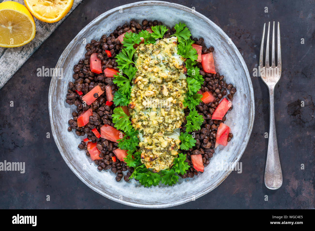Pesto - verkrusteten Kabeljau mit Puy Linsen und Tomaten - Ansicht von oben Stockfoto