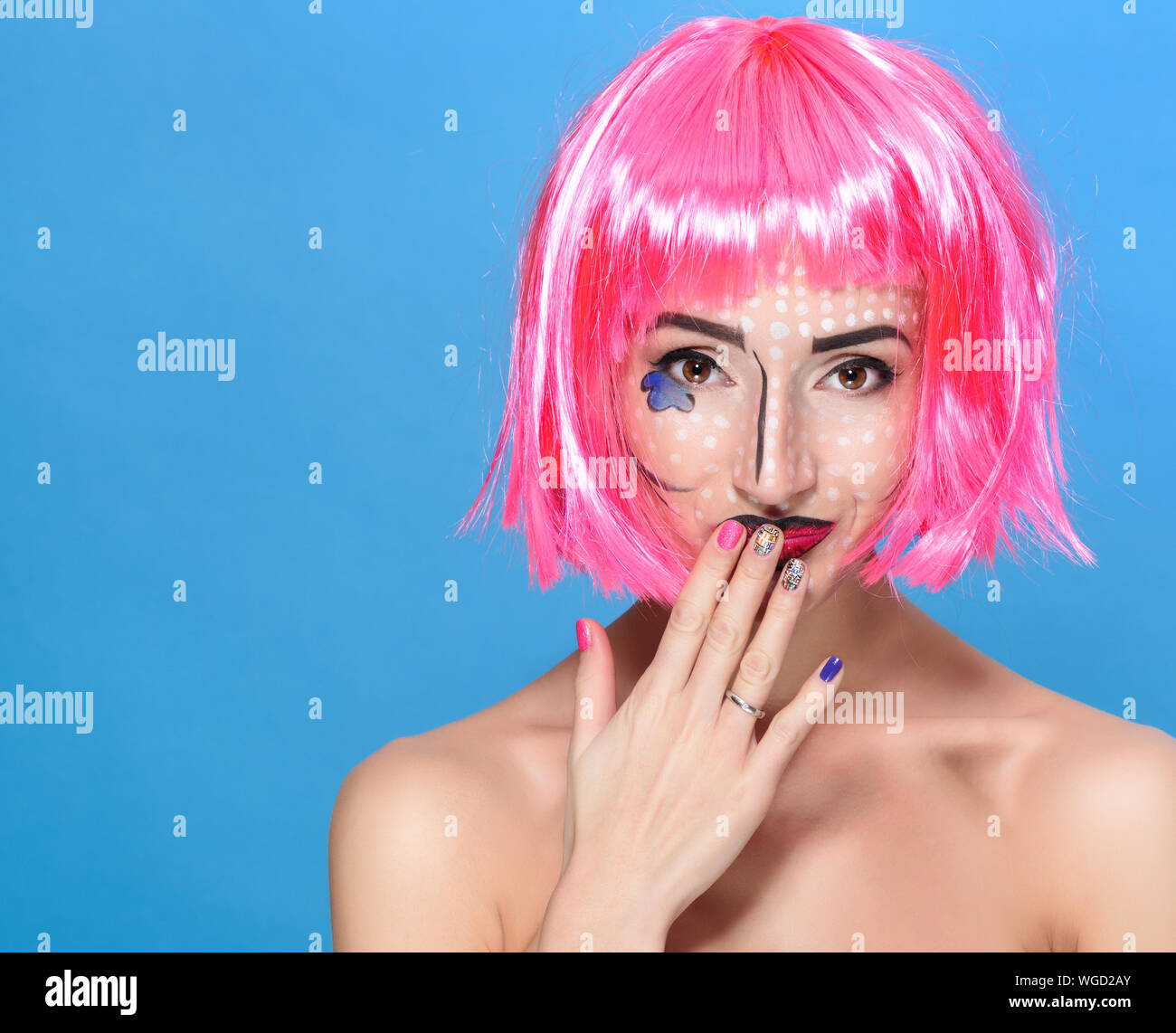 Beauty Kopf schoss. Junge Frau mit kreativen Pop Art süß und rosa Perücke mit Blick auf die Kamera auf blauem Hintergrund. Stockfoto